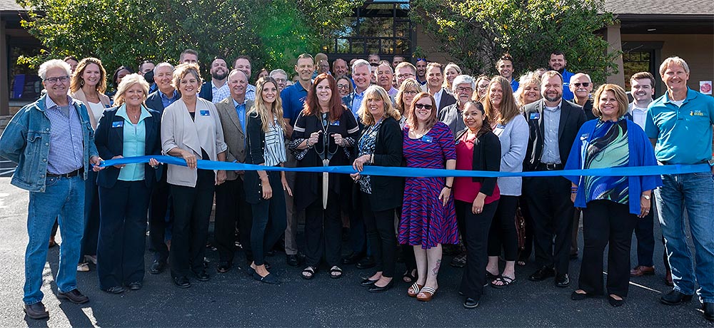 Group of team members cutting a ribbon