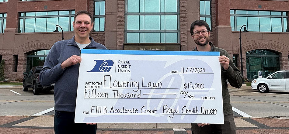 Two business people holding a large check