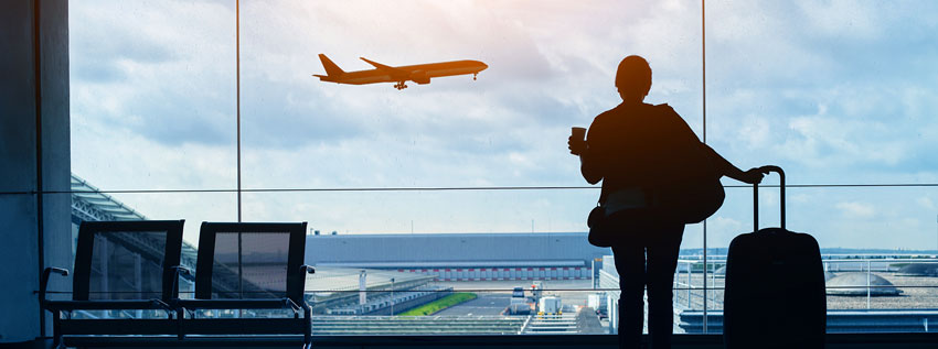 Person at the airport watching a plane fly away