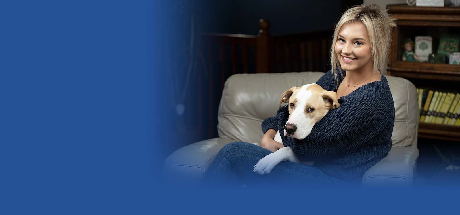 Young adult woman in with her dog and phone