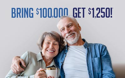 Older couple sitting together with copy saying Get a $1,250 bonus when you bring $100,000