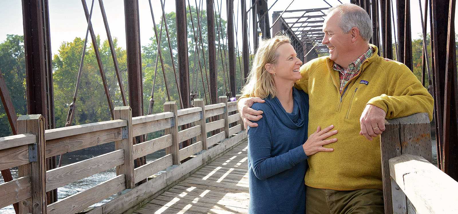 Older couple looking at each other on a bridge