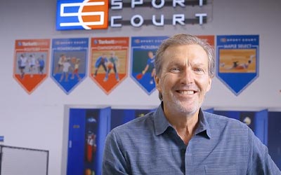 Business owner standing in front of his logo