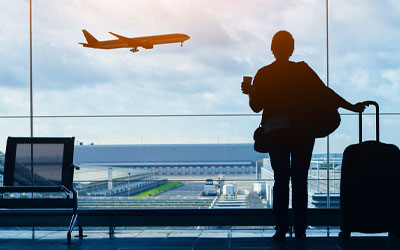 Person at the airport watching a plane fly away