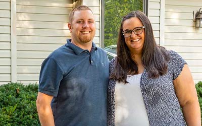 Happy family in front of new home